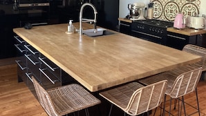 A modern kitchen with a central island, stainless steel appliances, and a patterned backsplash. - Charming town house with pool and garden (Périgueux)