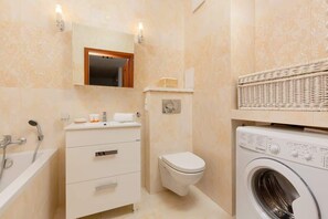 Bathtub, hair dryer, towels, shampoo