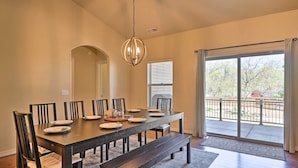 A dining room with a large table, chairs, a bench, a chandelier, and a view through a sliding glass door to an outdoor area. - 'Mount Elden Retreat:' 4 Mi to Downtown Flagstaff (Flagstaff)