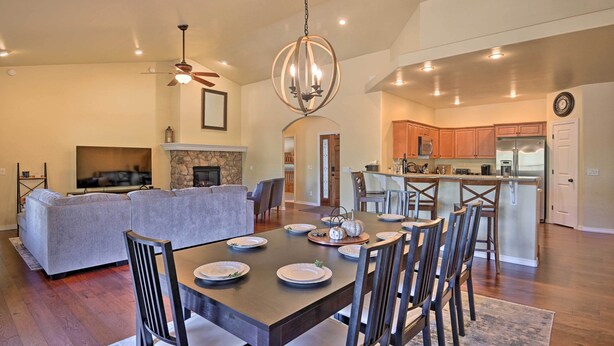 A spacious living room with a fireplace, a dining area with a wooden table set for four, and a kitchen with modern appliances. - 'Mount Elden Retreat:' 4 Mi to Downtown Flagstaff (Flagstaff)