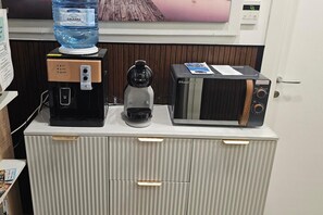 A kitchenette with a water dispenser, coffee maker, and a microwave on a cabinet. - Lovely Bed and Breakfast in Center of Sorrento (Sorrento)