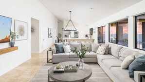 A modern living room with a sofa, coffee table, and artwork on the walls. - Upscale Red Rock Retreat- Spa, Views, Pet Friendly (Sedona)