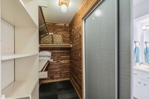 Bathroom features a bench, shelf, and mirror with overhead lighting.