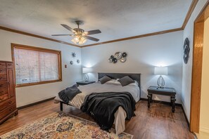Cozy retreat with a central bed, bedside lamps, and a dresser.