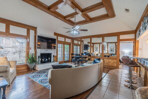 Relax and socialize in this open-plan living space featuring a sofa, dining area, and bar.