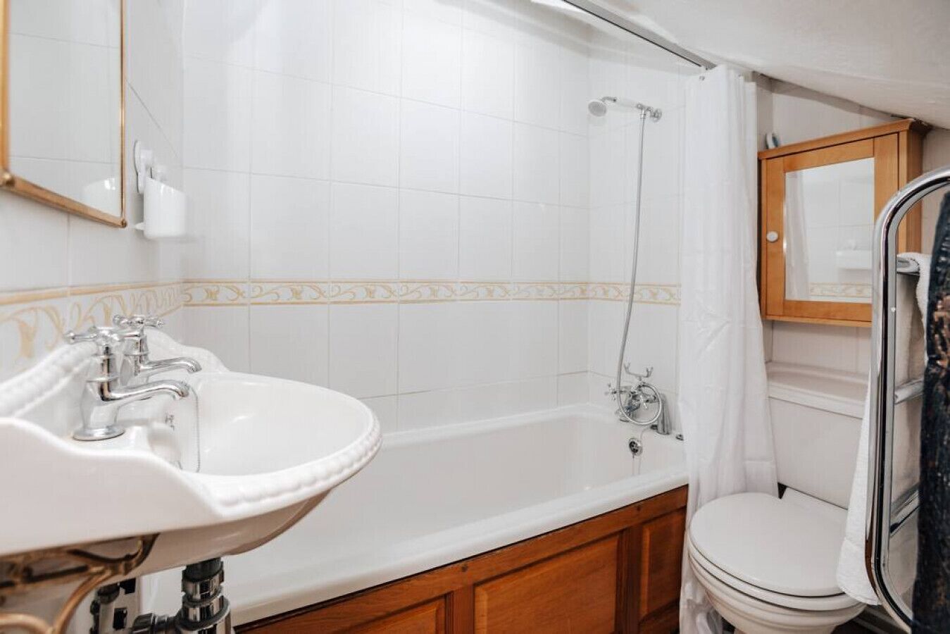 A bathroom with a white sink, a bathtub, and a toilet.