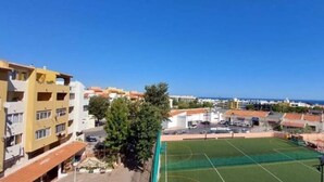 Une vue d’un terrain de sport, avec un ciel dégagé et des bâtiments en arrière-plan.