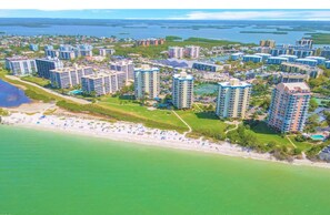 Zona residencial costera con edificios altos, una playa y un puerto deportivo.
