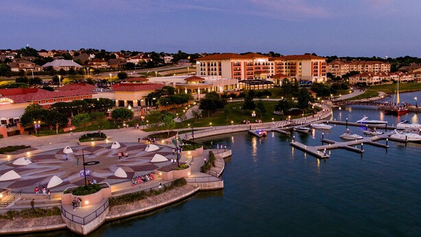 A marina with boats docked, a waterfront promenade, and a hotel in the background. - Sleeps 10*Pet Friendly*Kid Friendly*Near Dallas  (Fate)