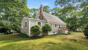 A single-story house with a brick chimney, a front porch, and a well-maintained lawn. - Minutes to Bayside Beaches, Dogs Welcome! (Eastham)