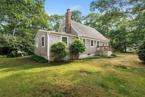 A single-story house with a brick chimney, a front porch, and a well-maintained lawn. - Minutes to Bayside Beaches, Dogs Welcome! (Eastham)