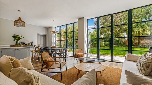 A spacious living area with a large window, a dining table, and a sofa. - Montpellier House, Centrally Located, Pet Friendly (Henley-On-Thames)