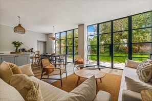 Un amplio espacio de sala con un ventanal grande, una mesa de comedor y un sofá.