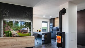 A modern living room with a fireplace, a wooden bench, and a large window overlooking a garden. - Fr Dlant Mcmp525 in Fr Dlant nad Ostravic (Frydlant nad Ostravici)
