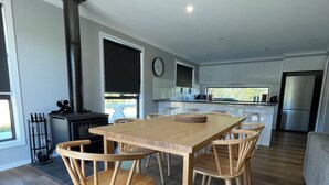 Una cocina moderna con una isla central, sillas de madera y un ventanal amplio.