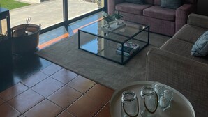 A spacious living room with a large glass door leading to a pool and a view of mountains.