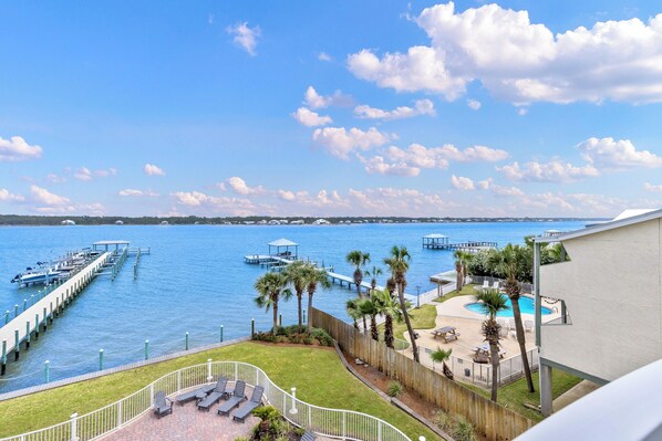 A waterfront property with a dock, a swimming pool, and a view of the water.
