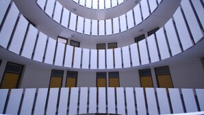 A circular atrium with a central skylight and multiple levels of balconies. - Modern apartment by the pool (Lignano Sabbiadoro)