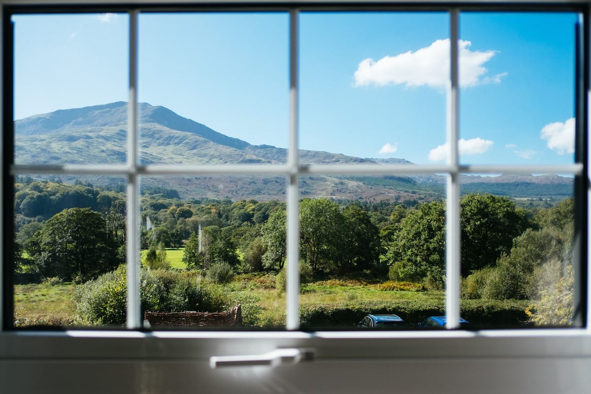 A window view of a mountainous landscape with a clear sky.