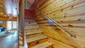 Eine Holztreppe mit Metallgeländer in einem Raum mit Holzboden und einem blauen Stuhl.