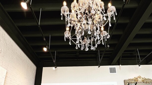A spacious room with a chandelier, a large mirror, and a view into another room through a set of doors. - 4 Luxury Suites in a beautifully restored historic building in Buffalo, Texas.  (Buffalo)