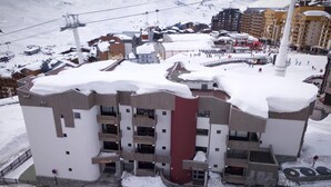 A multi-story hotel with balconies, a ski lift in the background, and snow-covered surroundings. - Ski-in/ski-out & foot of the slopes, 1st floor, view ski slopes, balcony, tv, 32m², Val Thorens (Val Thorens)