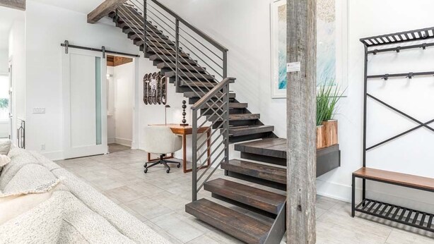 A modern interior with a wooden staircase, a white wall, and a bench. - Savannah Jetsetter | Pet Friendly, Luxury Townhome, Historic Savannah (Savannah)