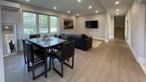 Amplia sala de estar con mesa de comedor, sofá y televisor.