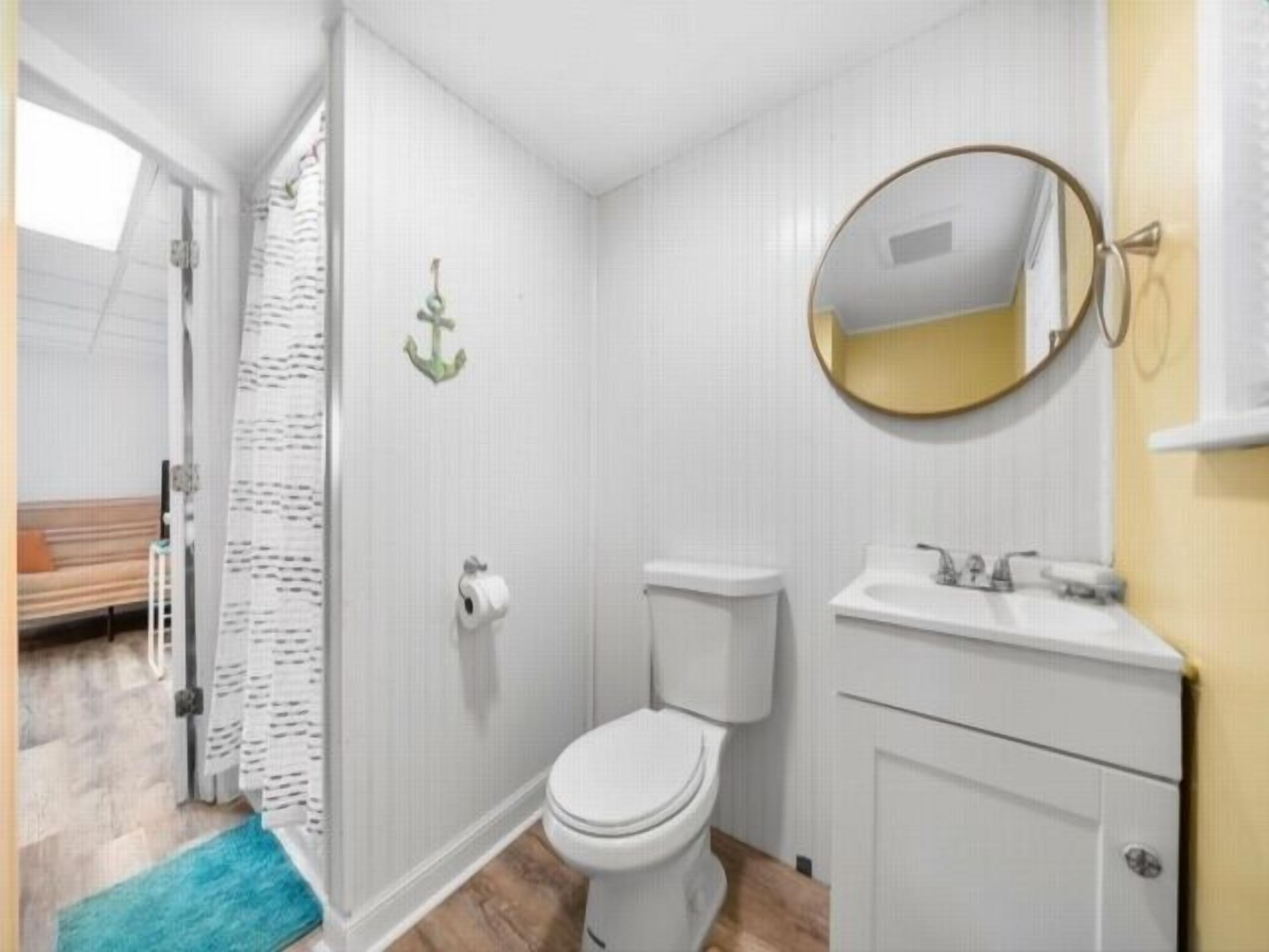 A small bathroom with a toilet, sink, and mirror.