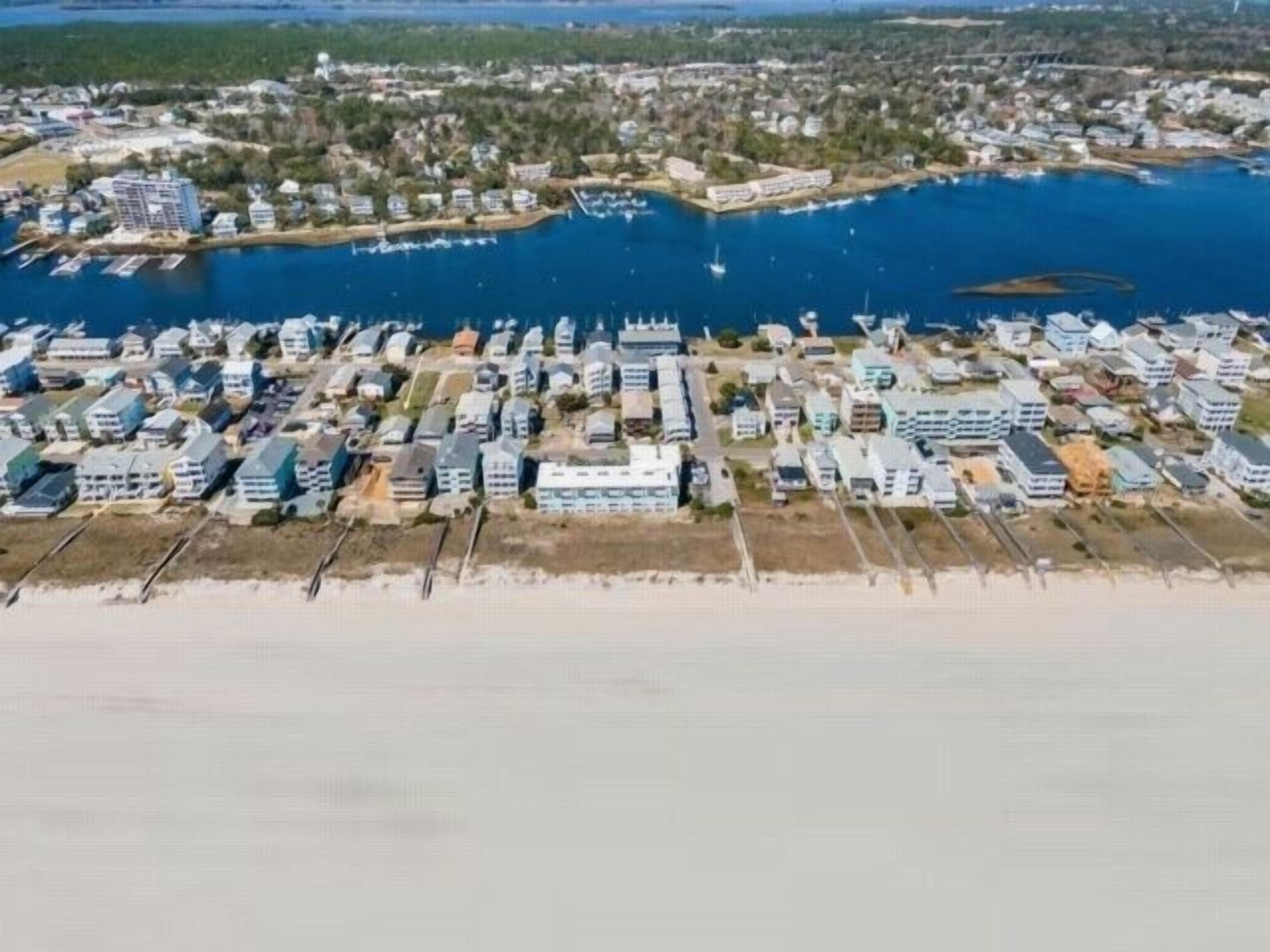 A coastal residential area with a marina and houses along the shoreline.