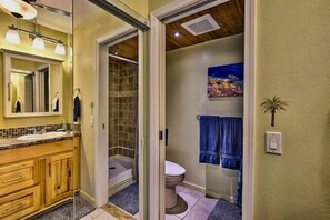 A bathroom with a wooden vanity, a glass shower enclosure, and a toilet.