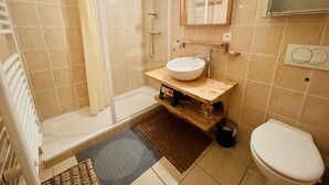 A bathroom with a bathtub, a sink, a toilet, and a shower. - Balcony & serenity: peak views (Le Monêtier-les-Bains)