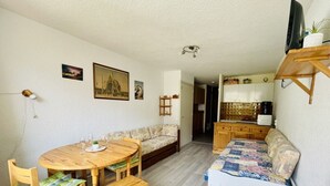 A compact living space with a dining table, sofa, and a small kitchen area. - Nice 28m² Comfort In The Heart La Salle Les Alpes (La Salle-les-Alpes)