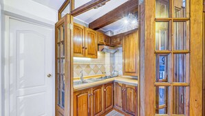 Une cuisine avec des meubles de rangement en bois, un évier et une cuisinière.