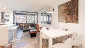 A modern living space with a dining area, a sofa, and a coffee table.