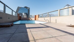 A rooftop pool area with a clear view of a modern building in the background.