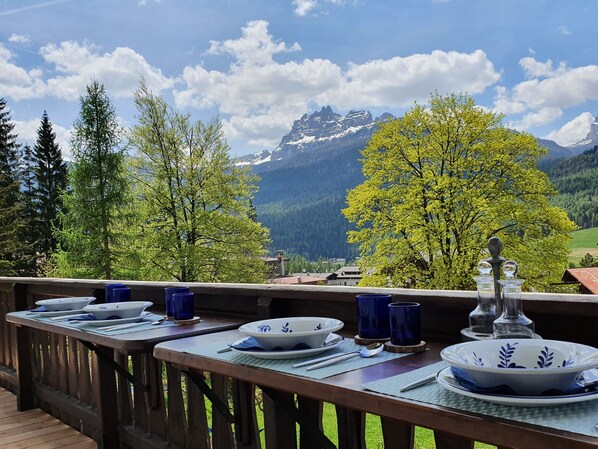 A dining table set outdoors with a mountain view.