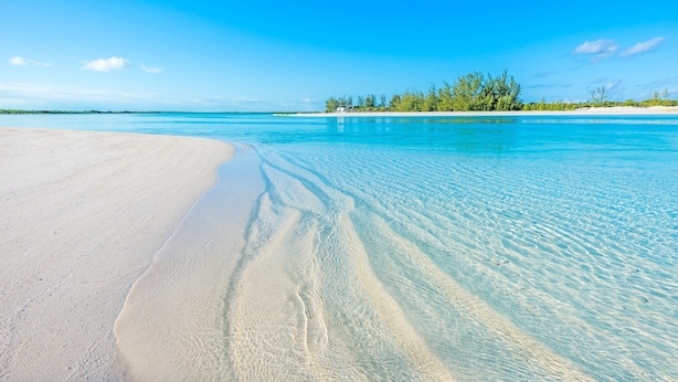 Ein Strand mit klarem türkisblauem Wasser und weißem Sand.