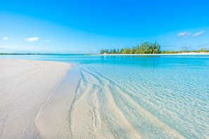 Una playa con agua turquesa cristalina y arena blanca.