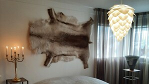 Una camera da letto con un grande letto, un candelabro, un rivestimento in pelliccia e un lampadario.