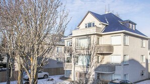 Un edificio residenziale a più piani con tetto spiovente e diversi balconi.