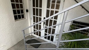 Un escalier avec des rampes en métal mène à une porte blanche sur laquelle est inscrit le chiffre « 3 ».