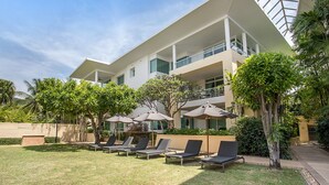 Um hotel moderno com terraço no telhado, área de estar ao ar livre e vegetação exuberante.