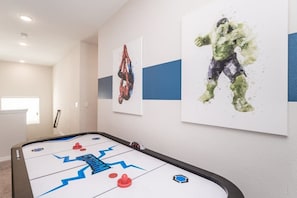 A room with a shuffleboard table, a window, and two framed artworks on the wall. - West-Facing House with Private Pool & Hot Tub (Kissimmee)