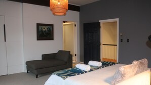 Um quarto com cama, sofá e um quadro na parede.