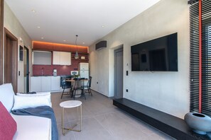 A modern interior with a dining area, kitchen, and a TV mounted on the wall. - Metatulia 1 villa,sea views,pool,Souda,Plakias (Plakias)