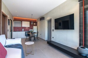 A modern interior with a dining area, kitchen, and a living space with a sofa and a small table.