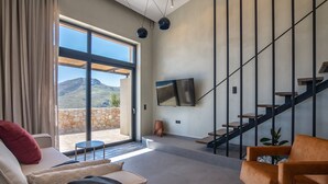 A spacious living area with a sofa, a coffee table, and a staircase leading to a balcony. - Metatulia 3 villa,sea views,pool,Souda,Plakias (Plakias)