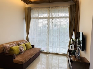 Apartamento, várias camas | Sala de estar | TV 30 polegadas com canais a cabo