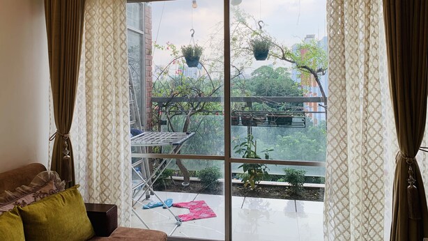 Une pièce avec une grande fenêtre, un étendoir métallique et une petite table.
